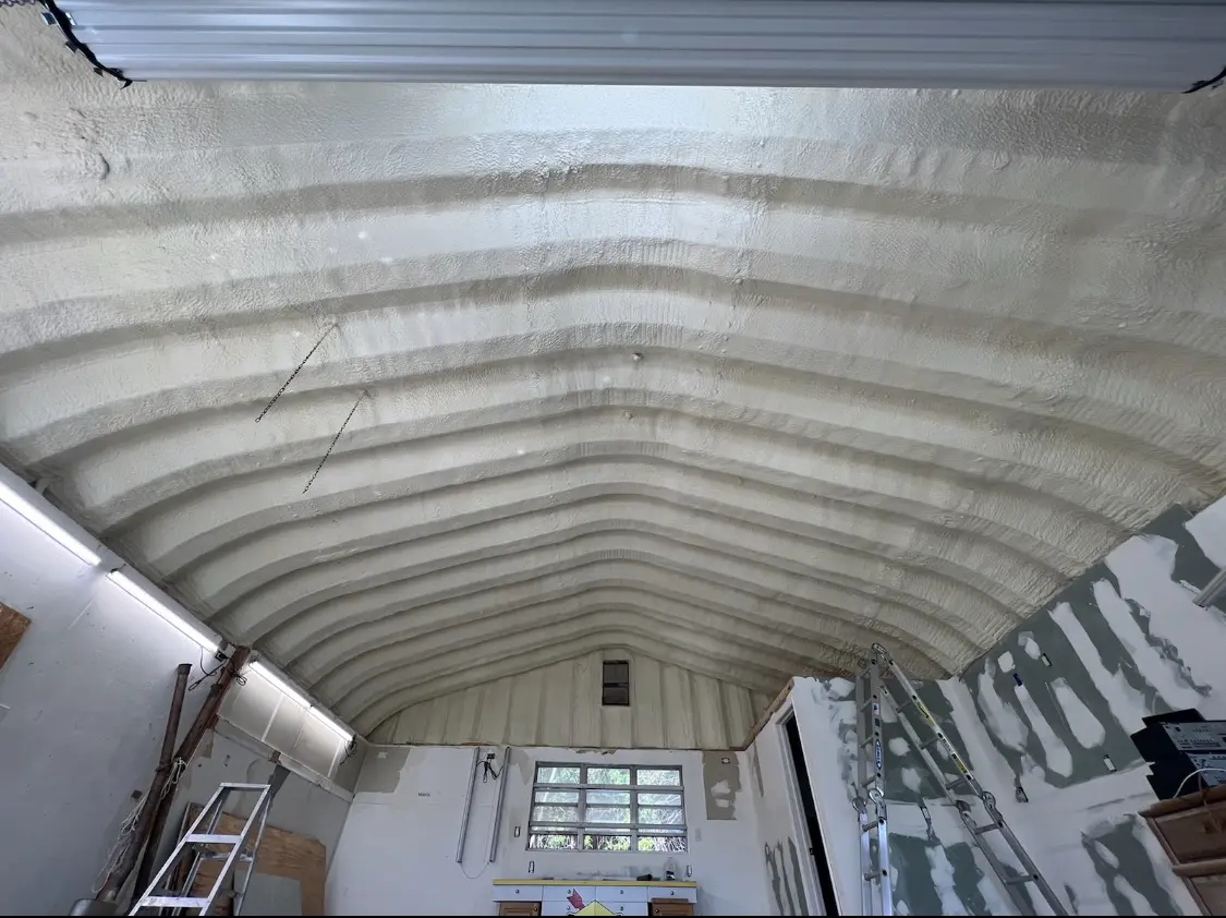 Spray polyurethane foam applied to the underside of a metal roof deck in Norton